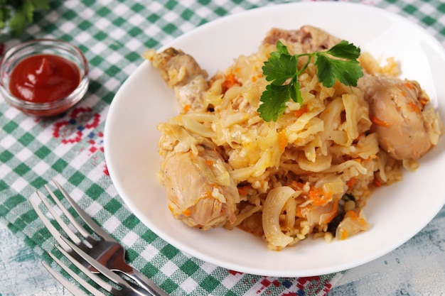 Closeup of chicken legs with rice and cabbage in white plate