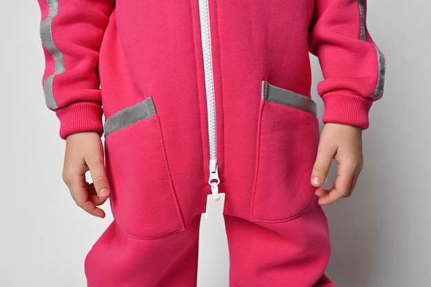 Closeup of a child in a bright pink fuchsia jumpsuit with a zipper and pockets