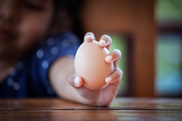 卵を持って子供の手の上にクローズアップ