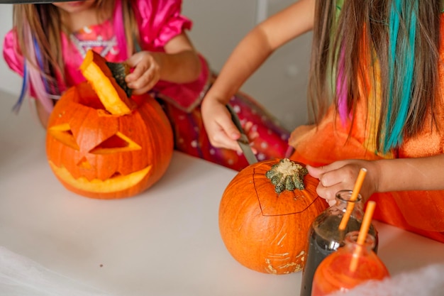 Closeup of children at table carving pumpkin faces