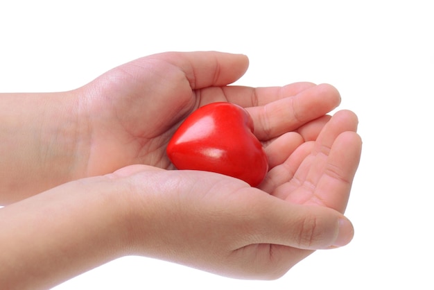 Closeup of a childs hands holding a small red heart