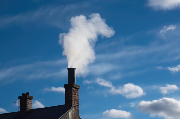 Closeup of chimney with smoke billowing out against bright blue sky created with generative ai