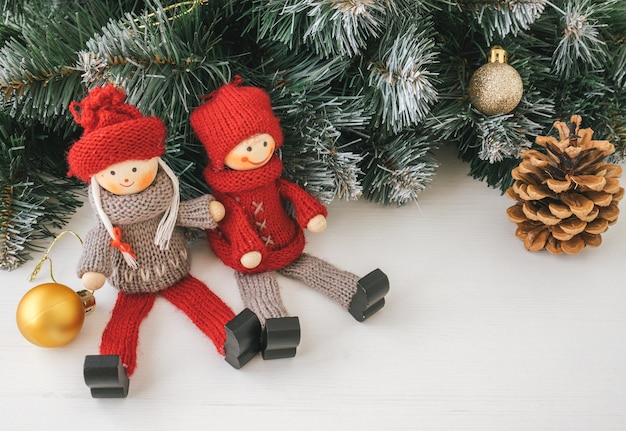 Closeup of christmas toys with christmas tree branch on bright wooden background.