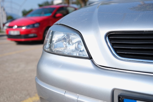 Primo piano dei fari puliti dell'auto argentata nel parcheggio