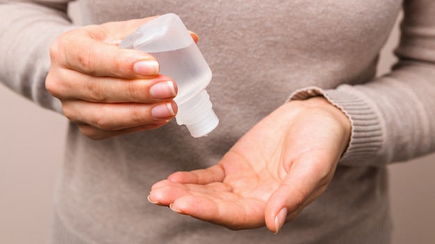 Closeup clean woman hands using sanitiser to disinfect her hands. corect hygiene actions