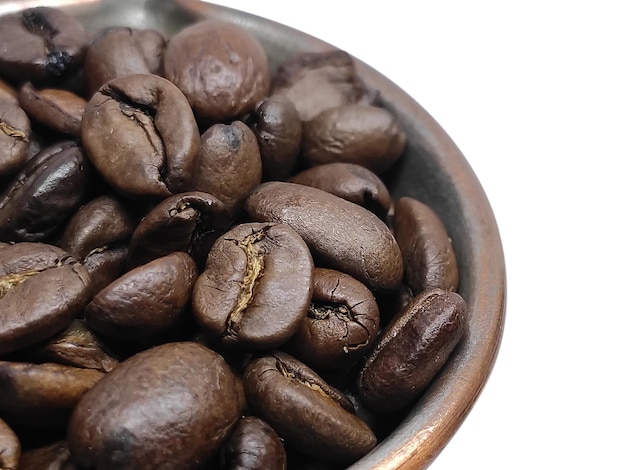 Photo closeup coffee beans in bowl isolated on white background. design element for wallpaper, poster, banner or business card.