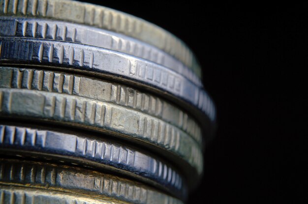 Closeup of coins stack isolated on black background