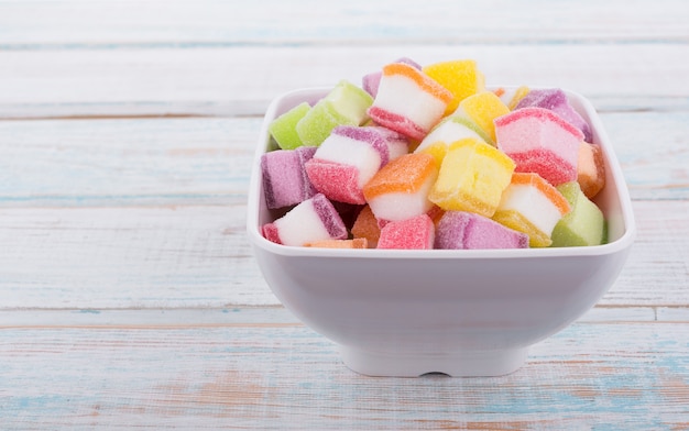 closeup colorful candy and jelly sweet in bowl on wooden