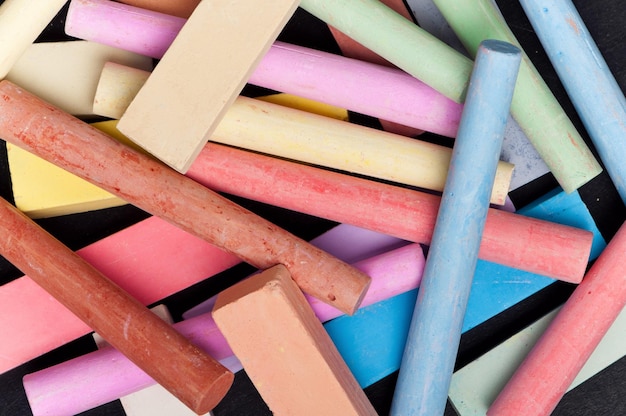 Closeup of colorful large chalk sticks on blackboard