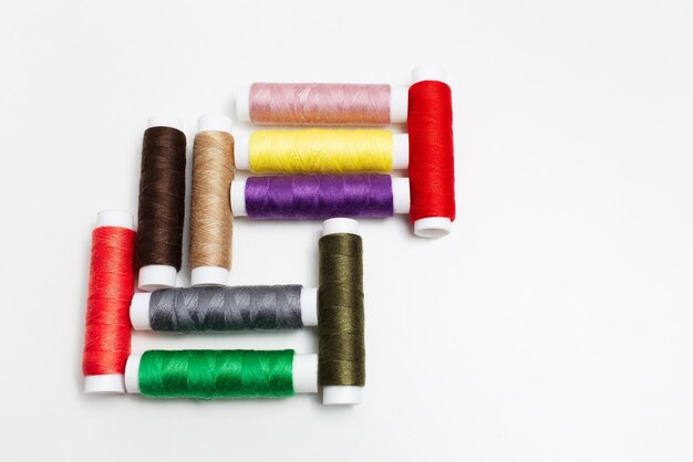 Closeup of colourful set of thread spools on white background