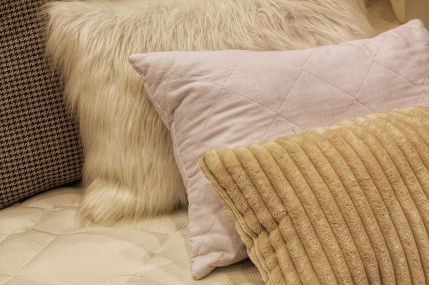 closeup of comfortable colorful soft pillows on bed stylish trendy apartment home decor hygge sca