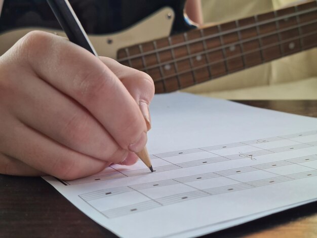 Primo piano delle note di scrittura a mano della ragazza del bambino del compositore in taccuino