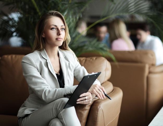 Closeup of confident business woman with documents in the business center