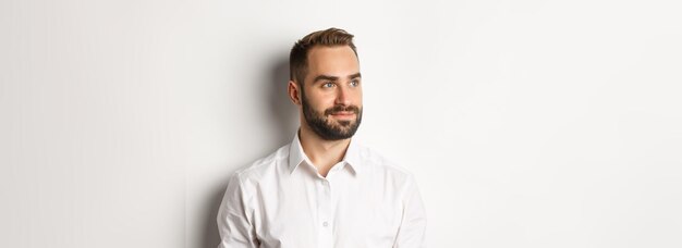 Photo closeup of confident businessman in white shirt looking left and smiling satisfied standing over whi