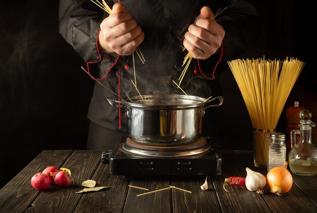 Closeup of cook hands while cooking in kitchen Cucina italiana