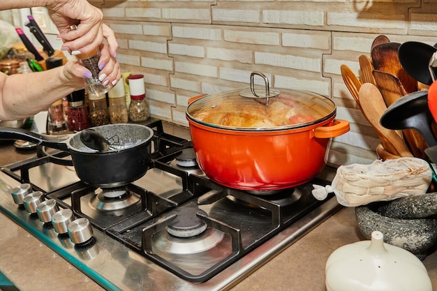 Closeup of cook's hands whisking beaten eggs and adding freshly ground pepper from shaker