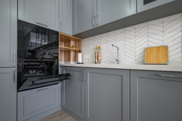 Closeup to corner of grey and white modern kitchen furniture