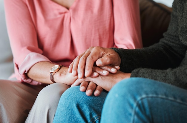 closeup couple and holding hands to forgive love and care with empathy at home life partner helping hand and support of man woman and hope for kindness trust or gratitude for therapy of anxiety