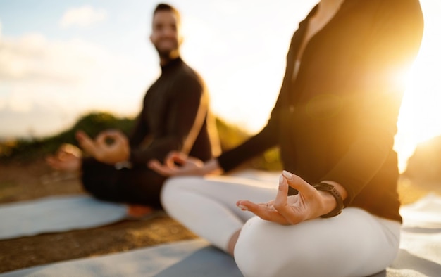 Photo closeup of couple in lotus position practicing meditation