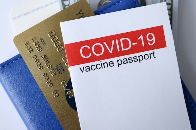 Closeup of covid 19 vaccination passport and credit bank card. Traveling during pandemic covid19 concept