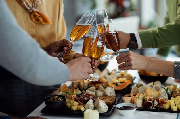 Closeup of coworkers toasting with Champagne on a party in the office