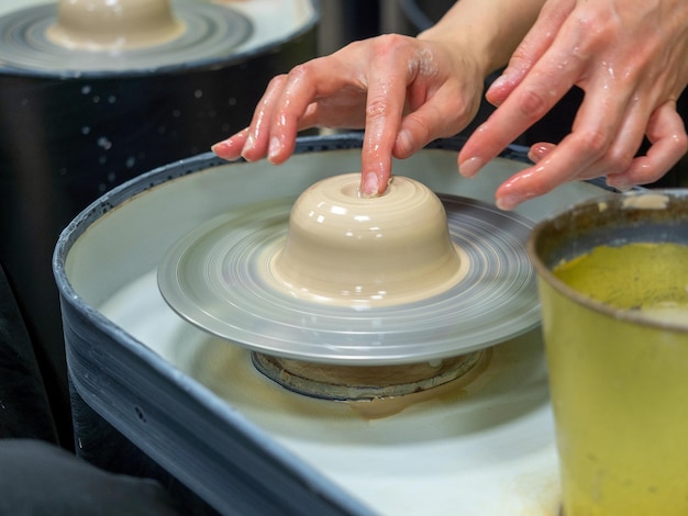 A closeup of a craftsman making an object out of clay on a potter's wheel Handmade hobby hobby