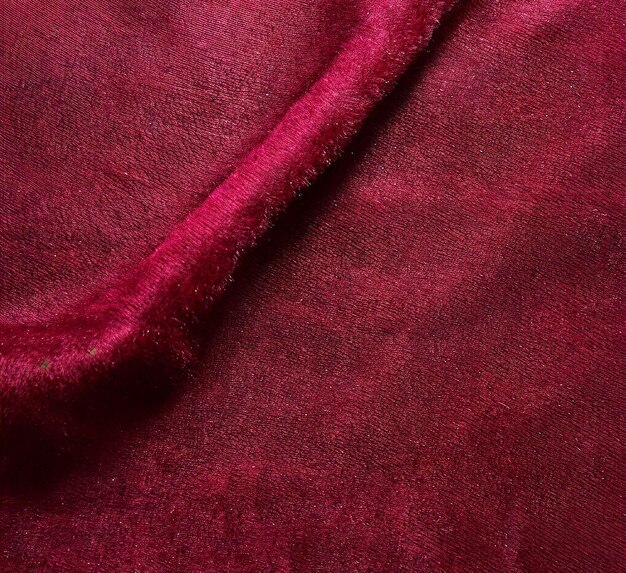 Photo closeup of a crimson velvet fabric under natural light