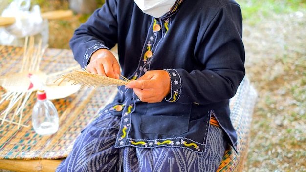 Primo piano e raccolto le tribù delle colline thailandesi tessono cestini di bambù come souvenir per i turisti