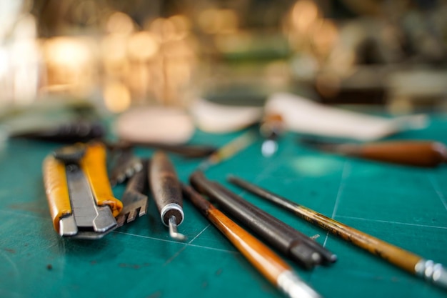 Closeup and crop tools and equipment for leather making on cutting bord and blurred background