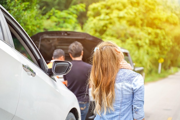 Closeup and crop woman suffering pain after car accident on country road with sun flare