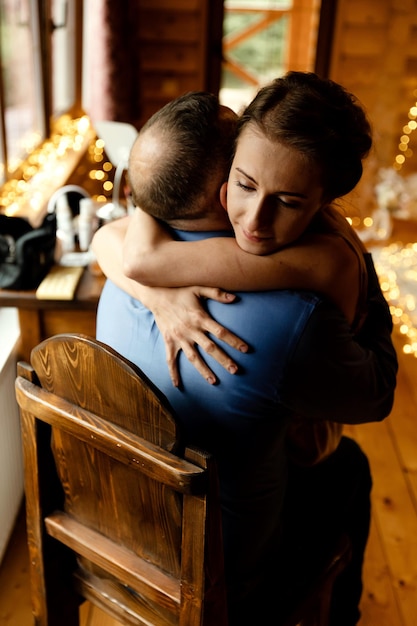 Foto primo piano di una ragazza che piange abbracciata dalle lacrime del padre sul viso della donna un forte abbraccio di sostegno