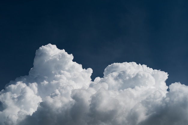 Il cumulonembo del primo piano si appanna di estate con cielo blu