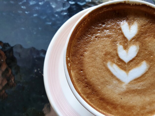 Primo piano una tazza di caffè latte art caldo sul tavolo