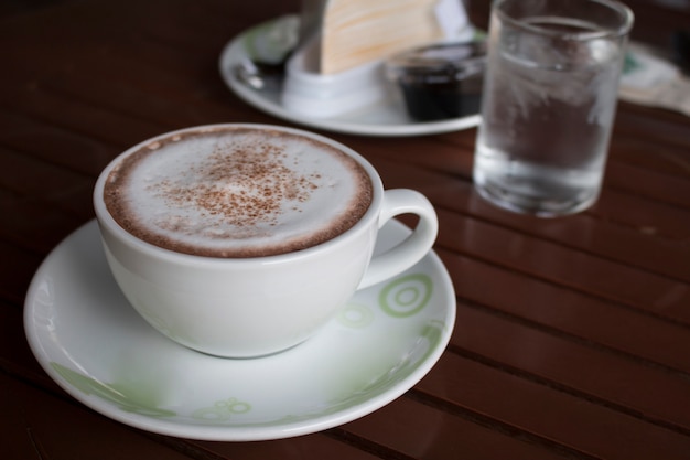 Closeup di una tazza di latte art caffè caldo su tavola di legno