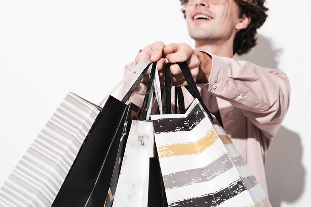 Closeup of customer holding purchases in paper bags isolated on white background