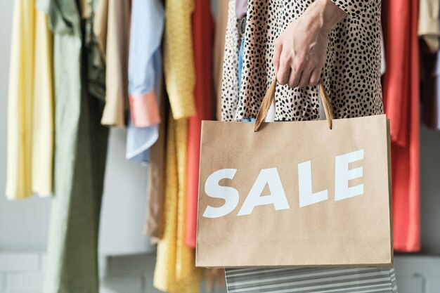 Closeup of customer with shopping bags standing in the shopping mall