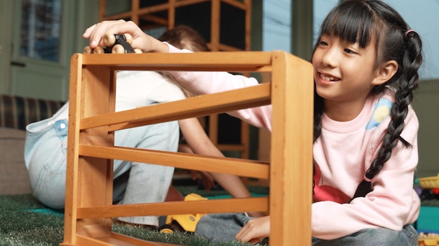 귀여운 아시아 소녀가 친구와 함께 놀이실에서 자동차 장난감을 하는 클로즈업