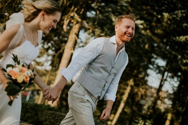 公園を歩いているかわいい若い新婚カップルのクローズアップ