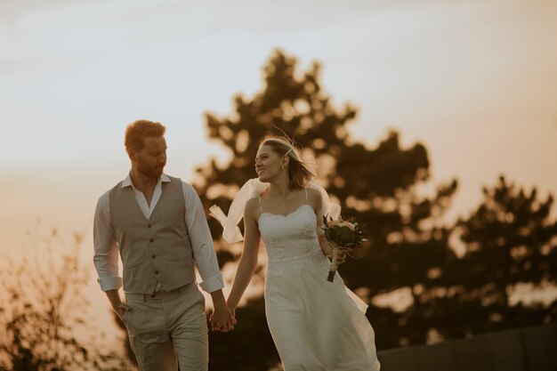 Closeup of the cute young newlywed couple walking in the park