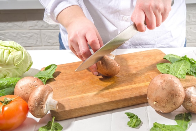 신선한 버섯을 절단 절단의 근접 촬영 여자 손으로 칼로 잘라 신선한 버섯 야채