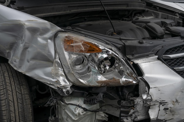 Photo closeup of the damaged car after a huge accident with broken headlights