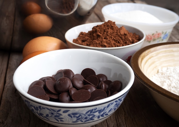 Фото Шоколад крупного плана темный в малом шаре. ингридиенты пирожных на деревянном столе.