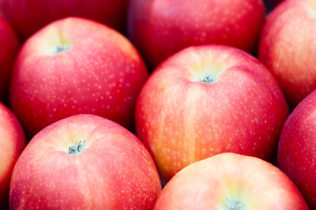 Photo closeup of a dark red apple between other apples