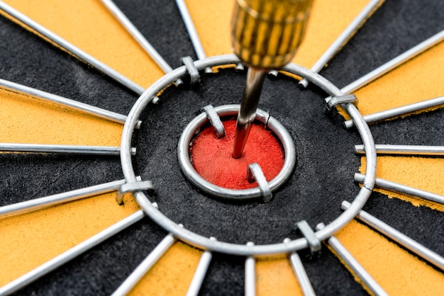 Photo closeup dart target with arrow on bullseye