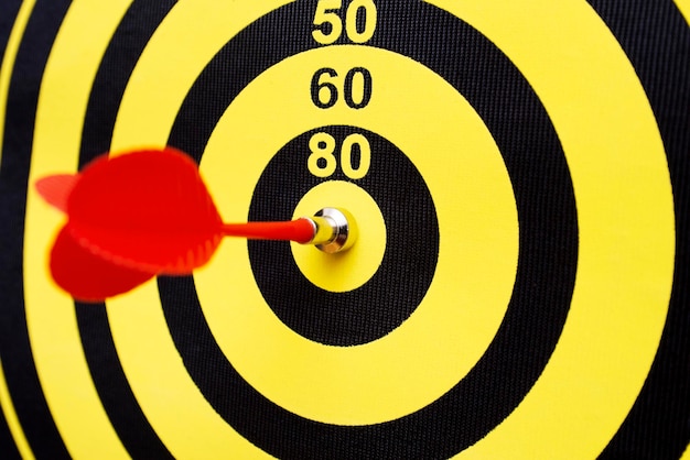 Closeup of a dartboard with yellow and red magnetic darts