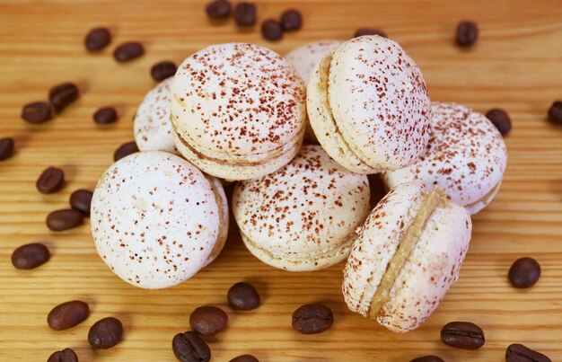 Photo closeup of delectable tiramisu macarons piled up on wooden background