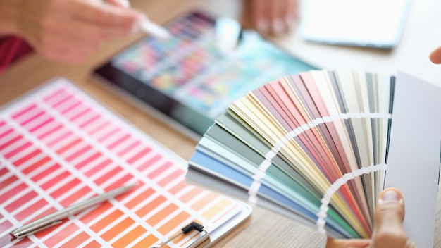closeup of designer holding fan of colourful paper samples in hand designer searching proper