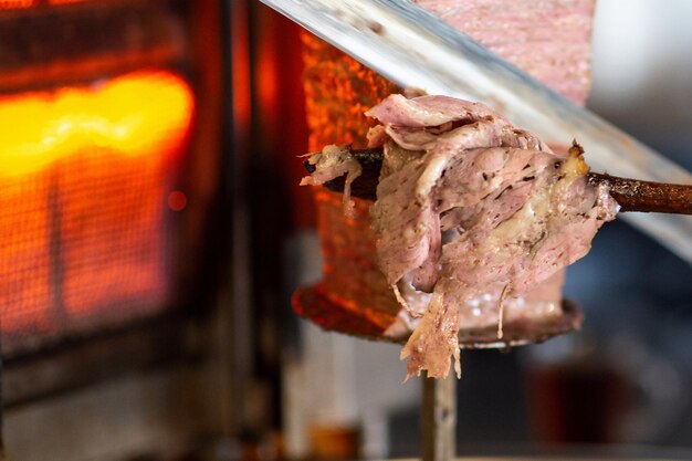 Closeup detail view of Turkish Doner chef is slicing the doner