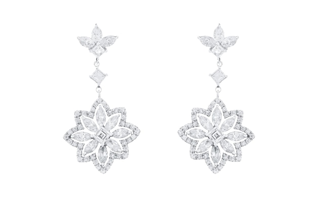 Closeup of diamond earrings shaped like snowflakes on a white background