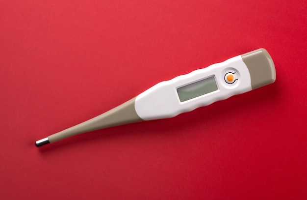 Photo closeup of digital thermometer on red